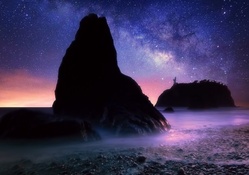 huge seashore boulders under starry sky