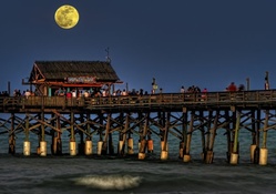 moon over tiki bar on a pier