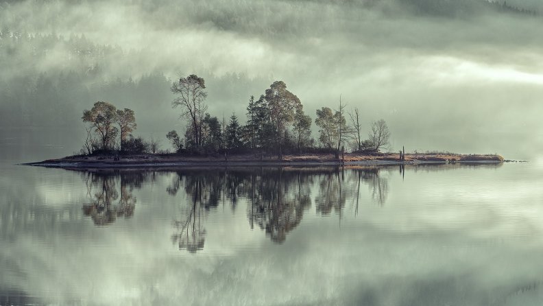 an island on a lake in mist