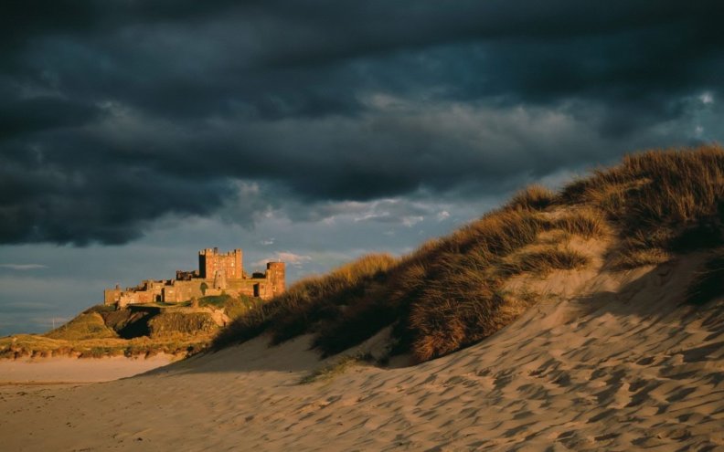 old_castle_on_a_sea_coast_under_stormy_sky.jpg