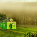 green house on a foggy river bank