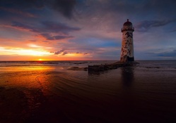 run down lighthouse at a gorgeous sunset