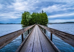 wooden pedestrian bridge to an island on a lake