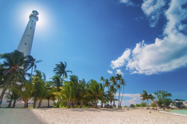 tall lighthouse on a tropical beach