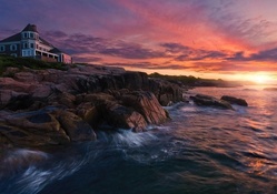 lovely home on a rocky seashore at sunset