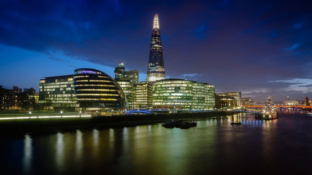 modern buildings by the thames river at night