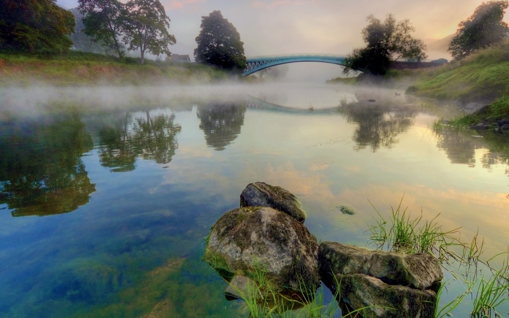 beautiful arched bridge on a foggy river