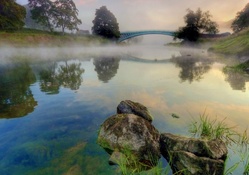 beautiful arched bridge on a foggy river