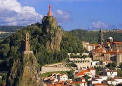 fantastic statue and church on cliffs above a town