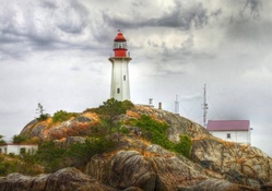 wonderful lighthouse on a rocky hill hdr