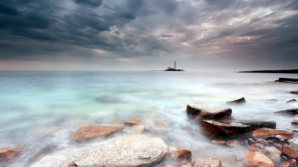 lighthouse on an island in a misty sea