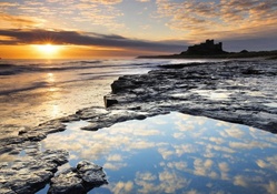 silhouette of bamburgh castle at sunset