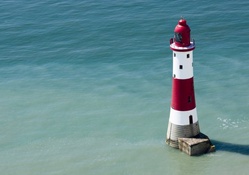 red and white lighthouse at sea