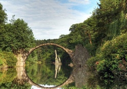 old bridge ruins make a circle in the river reflection