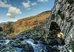 ancient stone bridge over rocky stream hdr
