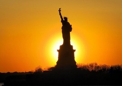 silhouette of the statue of liberty in sunset