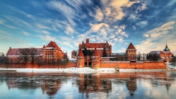 castle in poland by an icy lake in winter