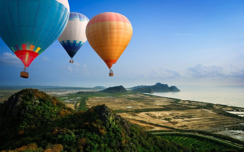 hot_air_balloons_flying_over_seacoast.jpg