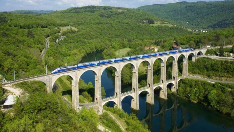 super train on and ancient bridge in france