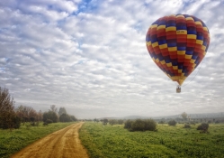 hot air balloon above a country road