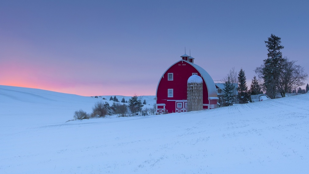 red barn and silo on a winter's sunset