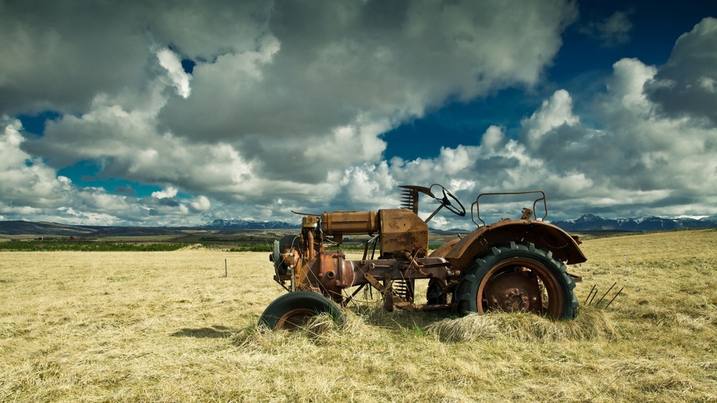 old rusty tractor in hay field