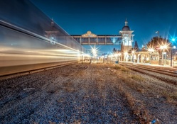 train passing a station at night in long exposure hdr