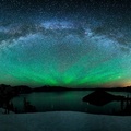 aurora borealis and the milky way above a lake