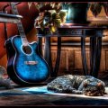 cat sleeping next to a blue guitar hdr