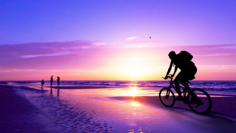 biking_on_a_beach_in_a_purple_sunset.jpg
