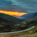road down a scottish valley at sunset
