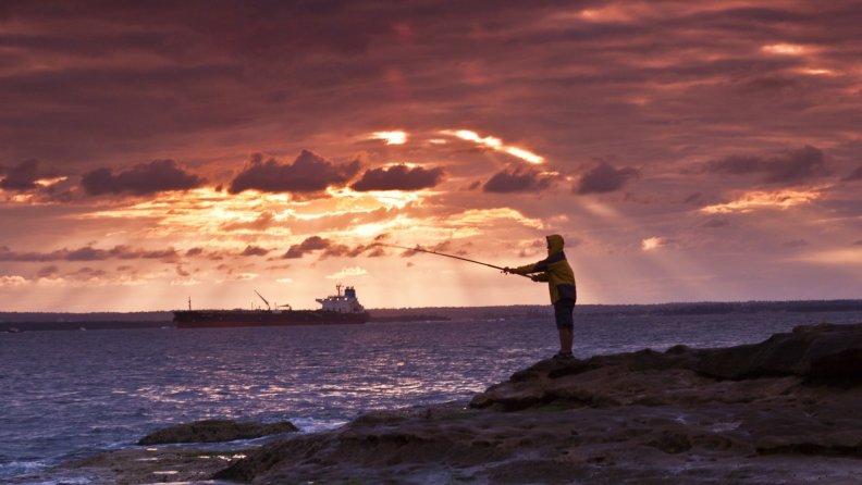 fisherman_on_a_rocky_bay_shore_at_sunset.jpg