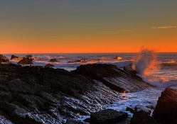 splashing waves on a rocky shore at sunset