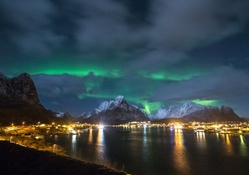 northern lights over a bayside village at night