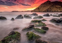 misty rocky seashore at sunset