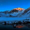moon over mountain lake in winter