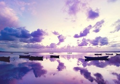 boats reflections in a purple ocean sunset