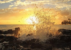 splashing waves at sunset in hawaii