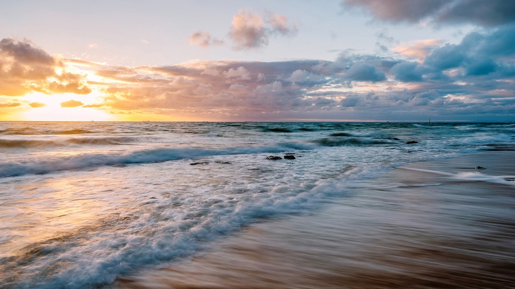 tranquil waves on a beach at sunset