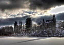 castle on a hill above a frozen lake hdr