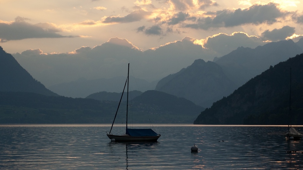 sailboat on an alpine lake at sundown