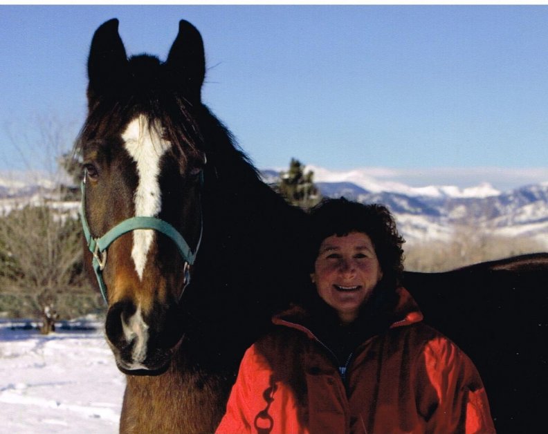 a true cowgirl with horse in the winter
