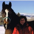 a true cowgirl with horse in the winter