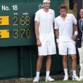 John Isner, Nicolas Mahut & Umpire standing next to the historic scoreboard after the longest match in Open history.