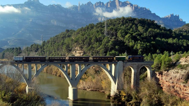 train on a rail bridge over a river gorge