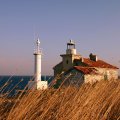 old lighthouse on a windswept grassy coast