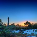 tall lighthouse among beach shrubs at twilight hdr