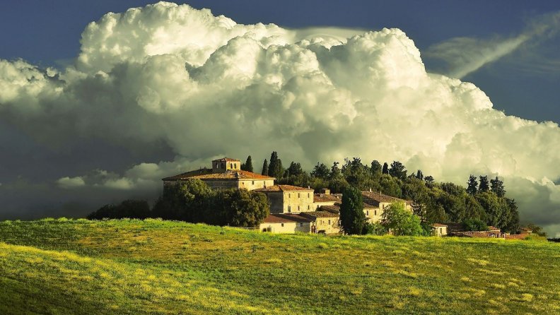 magnificent clouds over tuscan farm