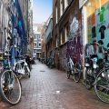 bicycles in a graffiti painted alleyway in amsterdam