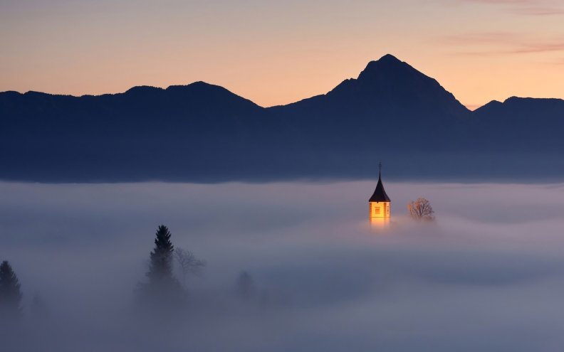 church tower peeking through morning fog